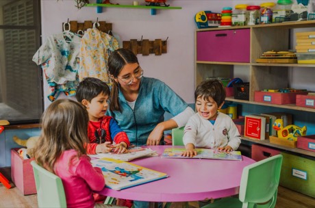Una tutora comparte la lectura con niños y niñas pequeños