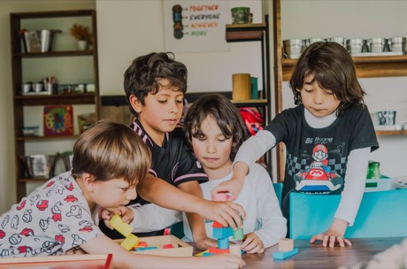 Niños construyen juntos con bloques de madera