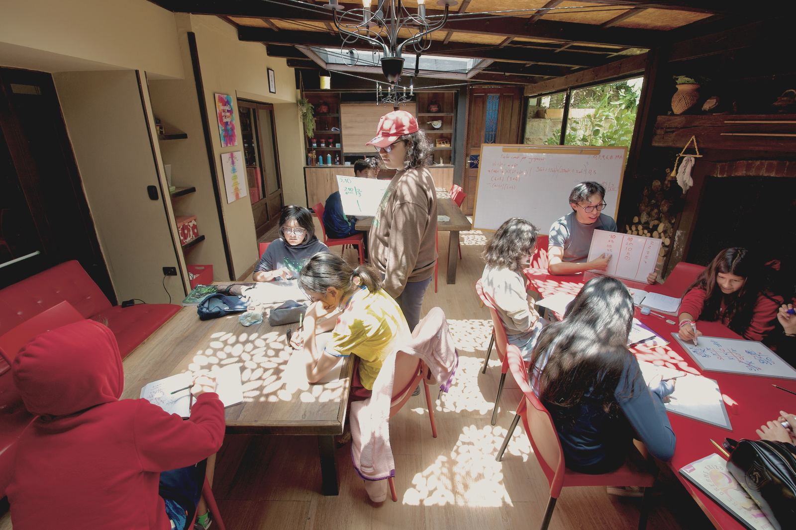 Un grupo trabaja matemáticas con tableros pequeños en un ambiente con luz natural