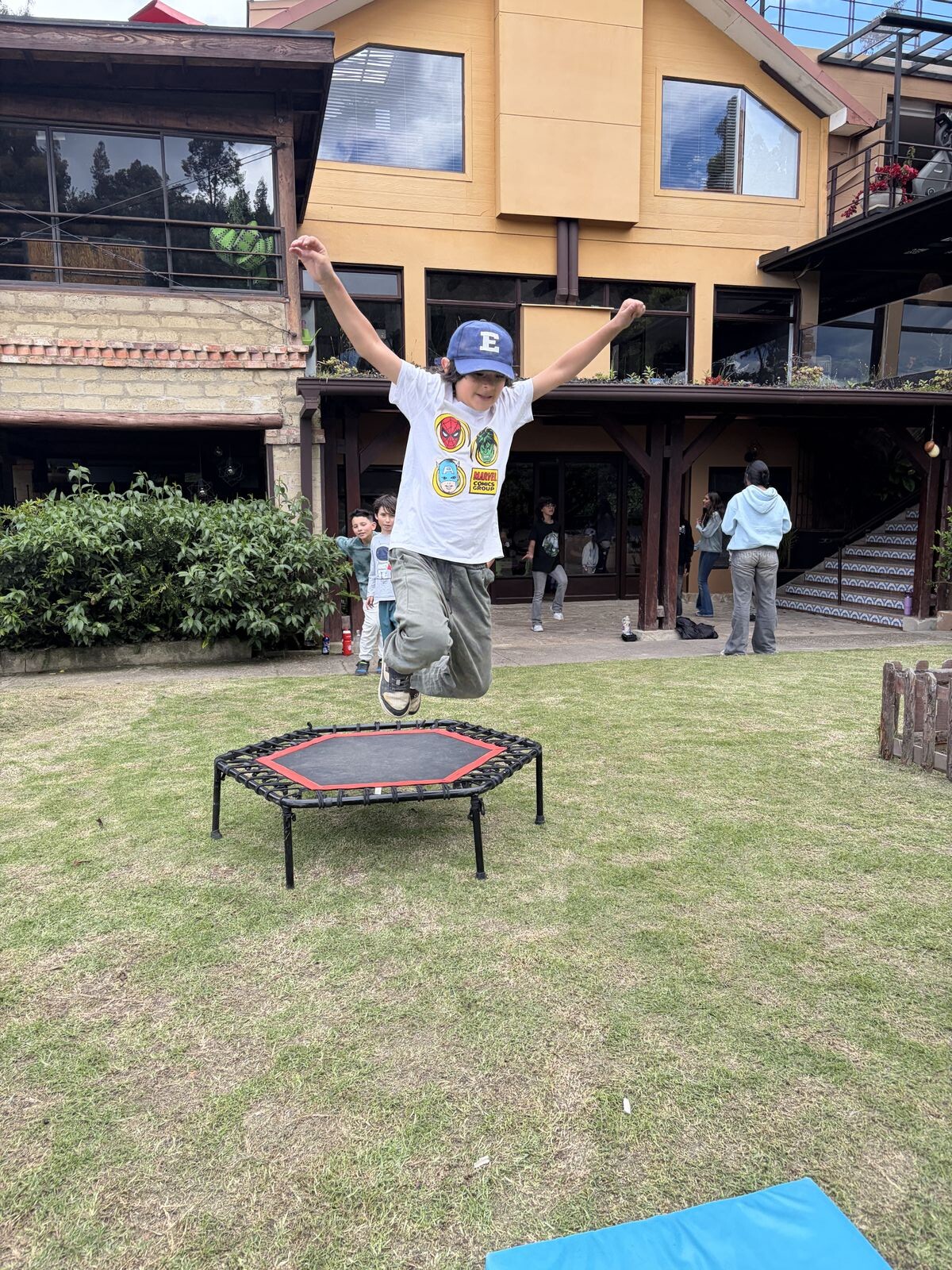 Un niño salta en el trampolín frente a la casa principal