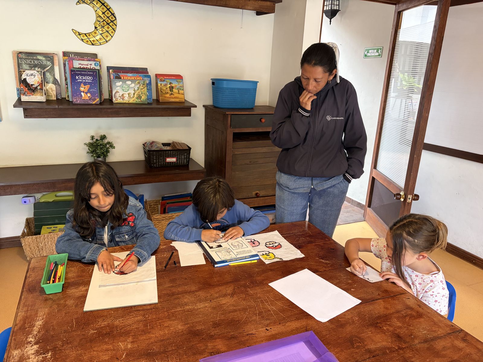 Una tutora acompaña a los estudiantes mientras dibujan